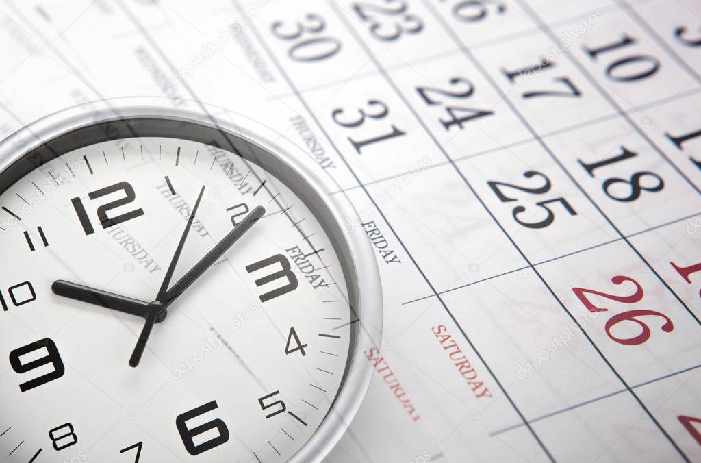 wall calendar with the number of days and white clock face closeup