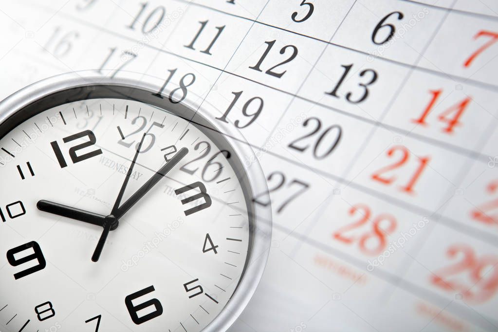 wall calendar with the number of days and white clock face closeup