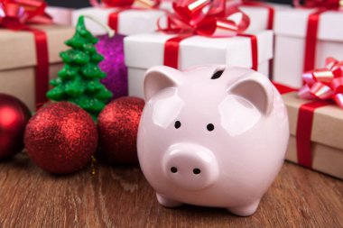 Noel oyuncak ve hediye kutuları arka planı ile Piggy banka