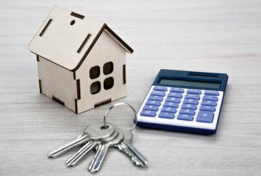 ahşap minyatür ev kapı tuşları ile ve bir hesap makinesi kapat