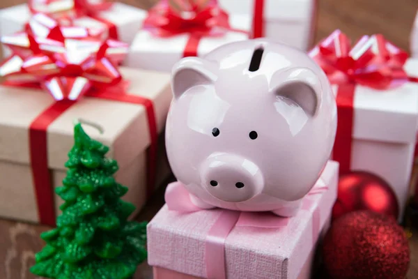 Sparschwein Mit Rosa Geschenkbox Vor Dem Hintergrund Von Weihnachtsspielzeug Und — Stockfoto