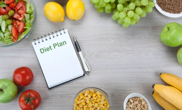 stock image notebook with a diet plan with fresh vegetables and fruits on th