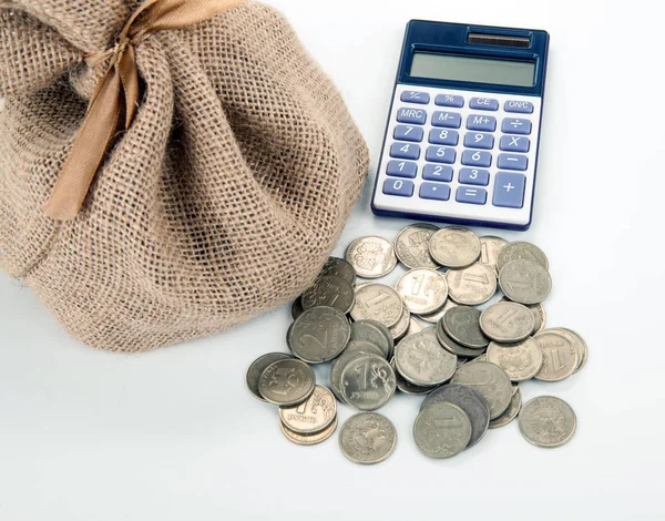 Ryska rubel mynt och kalkylator med pengar påse på en vit flik — Stockfoto