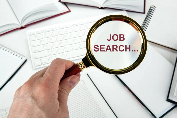 Magnifying glass in the hand and pc keyboard job search concept — Stock Photo, Image