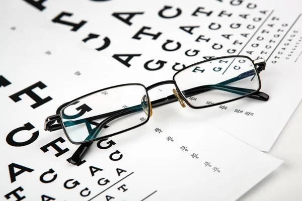 視力英語を決定するためのフォントでテーブルの上に眼鏡 — ストック写真