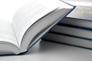 gri bir masada kitap yığını ile yeni açık kitap