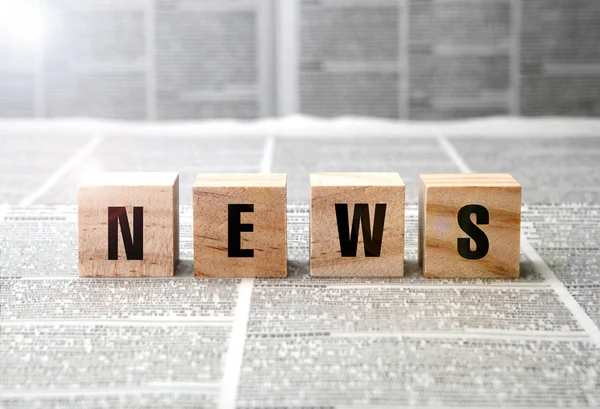 News title on square wooden blocks on a newspaper background — Stock Photo, Image