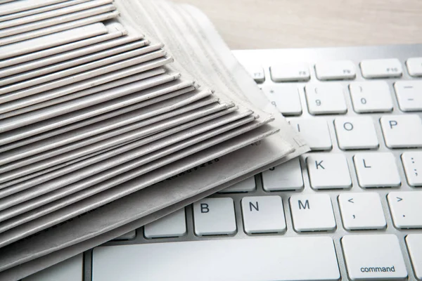 Stapels van talrijke gedrukte kranten op het PC-toetsenbord — Stockfoto