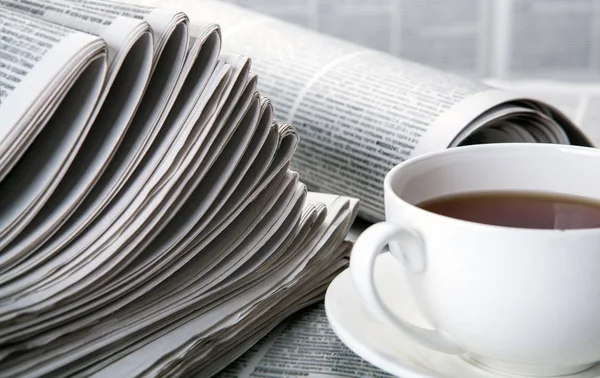 Jornais e uma xícara de café na mesa — Fotografia de Stock