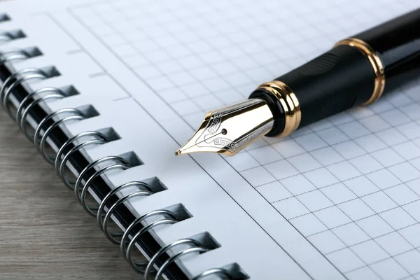 Fontän penna på anteckningsblocket på ett träbord — Stockfoto