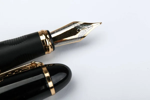 Золотая ручка на белой бумаге — стоковое фото