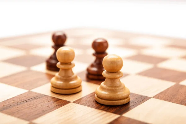 Chess pawns on a chessboard table on a white background — Stock Photo, Image
