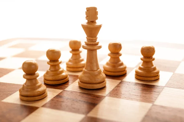 Pedaço de xadrez do rei branco cercado por peões — Fotografia de Stock