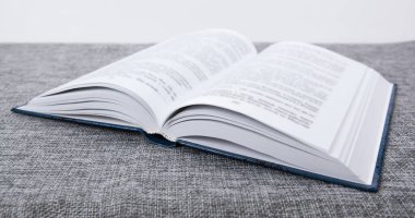 Gri masadaki yeni açık kitap. Yakın plan.