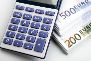 Hesap makinesi ve bir deste banknot. 500 ve 200 avro üst görünüm.