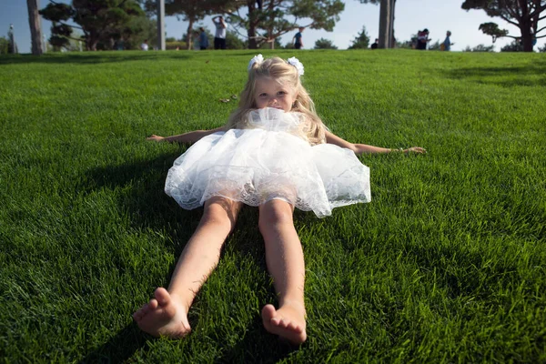 Маленькая Девочка Распущенными Волосами Платье Лежит Зеленой Траве — стоковое фото