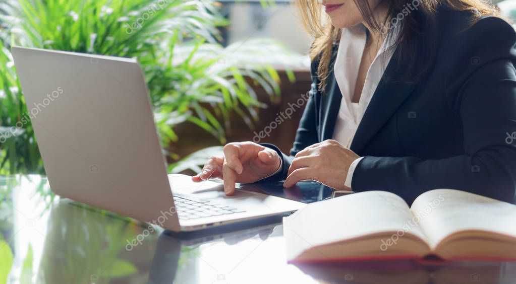 Business woman working with a laptop.. Business, legal law, advice and justice concept. Selective focus.