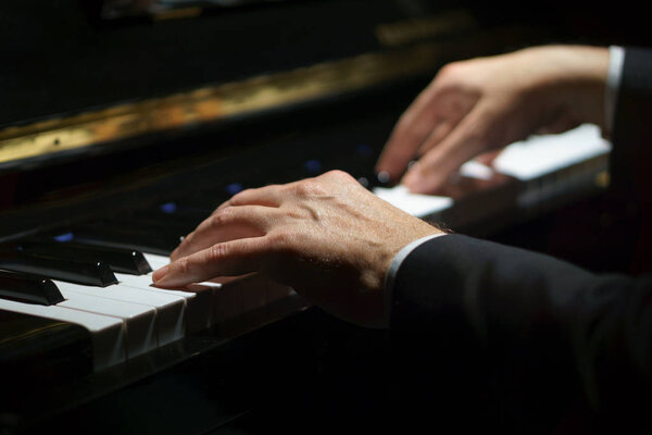 Professional musician pianist hands on piano keys of a classic piano.