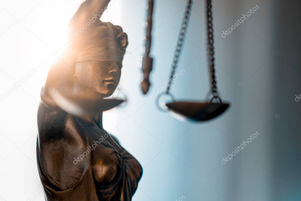 Statue of Justice with scales in lawyer office.