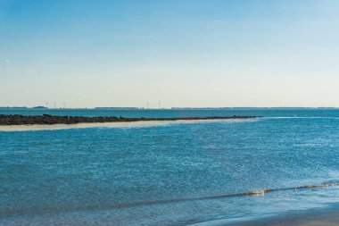 Sahilde uzaktan taşlarla dolu okyanus manzarası
