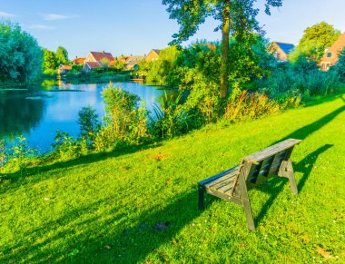 Göl Manzara ile güzel bir parkta küçük ahşap Bank