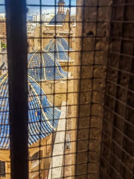 blue tower rooftops from a iron bars window view