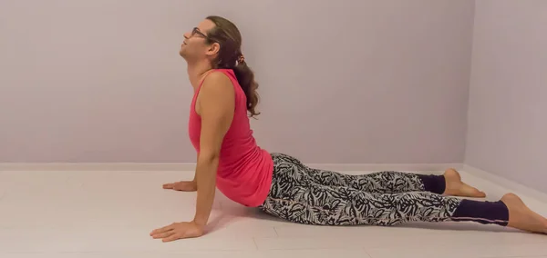 yoga upward facing dog - gymnastics seal stretch by a young transgender girl side view