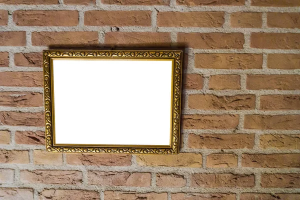 empty golden vintage painting frame hanging on a brick wall background