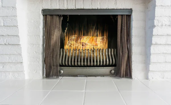 lighted and burning fireplace in retro style but with a modern look background architecture is of white brick stones and white tiling
