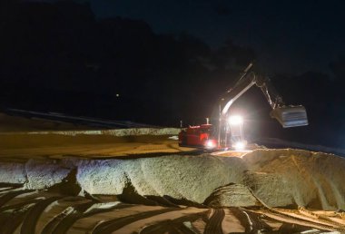 Kazıcı kazıcısı gece çalışıyor. Tamir için sahili yerinden oynatıyor.