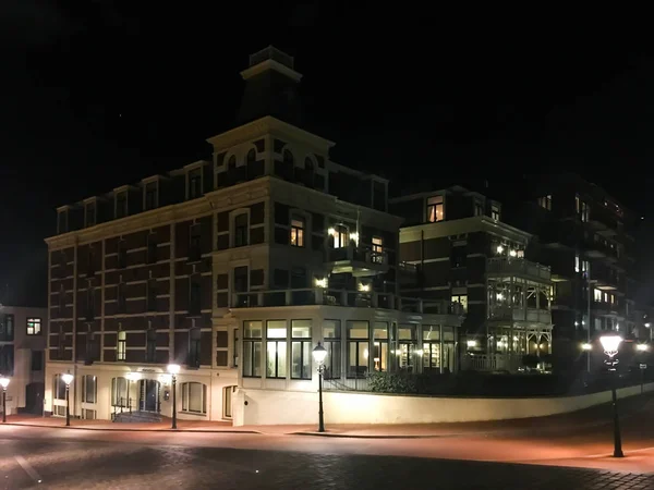 スケベニンゲン コンプレックスと街灯がたくさんの大きなマンションで夜の街 — ストック写真