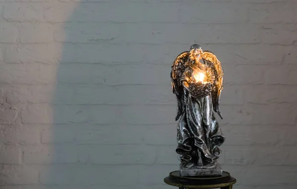 一个银色的天使雕塑 拿着点燃的茶光蜡烛 圣诞节和精神传统 — 图库照片
