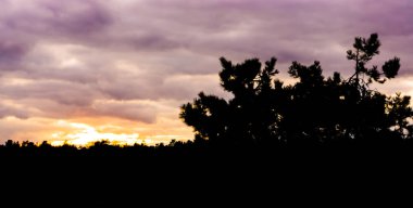 gün batımı karanlık siluetleri, renkli gökyüzü ve bulutlar heather peyzaj