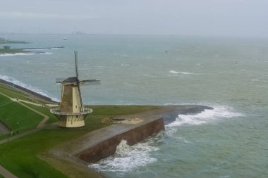 Vlissingen rıhtımındaki yel değirmeni. Vahşi deniz. Hollanda, Zeeland 'deki tipik bir Hollanda şehri.