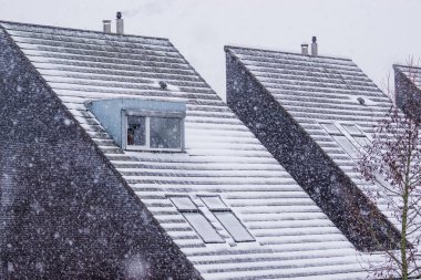 Kışın karla kaplı sivri çatılar, karlı hava, modern Hollanda mimarisi.