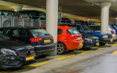 Kapalı otoparkta park etmiş arabalar, uzun sıra arabalar, ticari park yeri.