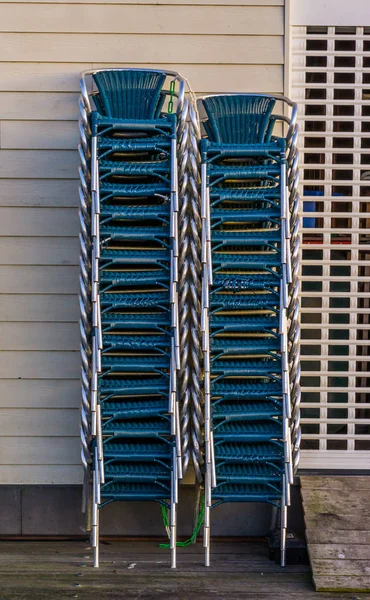 Chaises empilées à côté d'un volet roulant fermé, heure de fermeture dans l'industrie de la restauration — Photo