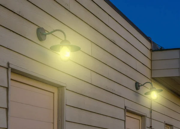 Vintage-Laternen hängen an der Holzwand eines Vintage-Hauses, Außenbeleuchtung im Retro-Stil, Lampen, die Licht in die Dunkelheit scheinen, Architekturhintergrund — Stockfoto