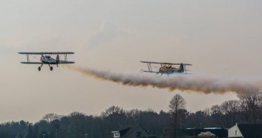 İki uçak dumanı tüten motorlarla havalanır, gökyüzünde uçan uçakları gösterir ve dublörlük yaparlar.