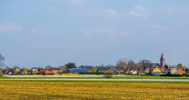 Kuzey Brabant, Hollanda 'da küçük bir köy olan Rucphen köyünün ufuk çizgisi, otlaktan manzaralı.