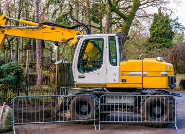 Bir inşaat sahasında modern kazıcı makinesi, yeni ekipman ve teknoloji, yer değiştiren endüstri geçmişi