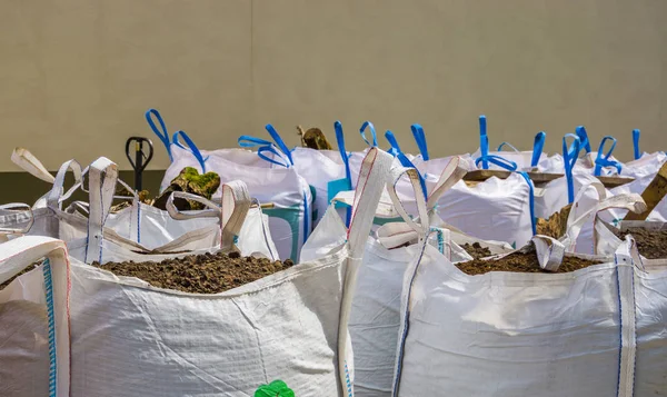 Pungi mari albe pline cu sol în ghiveci, horticultură și industrie agricolă, fundal logistic — Fotografie, imagine de stoc