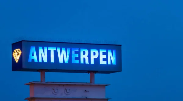 lighted blue neon light board with the text Antwerpen, Sign post illuminated by night in antwerp, Belgium