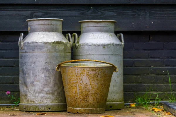 Starožitné zemědělské vybavení, plechovky z kovu a staré rezavé kbelíky, zemědělské zázemí — Stock fotografie