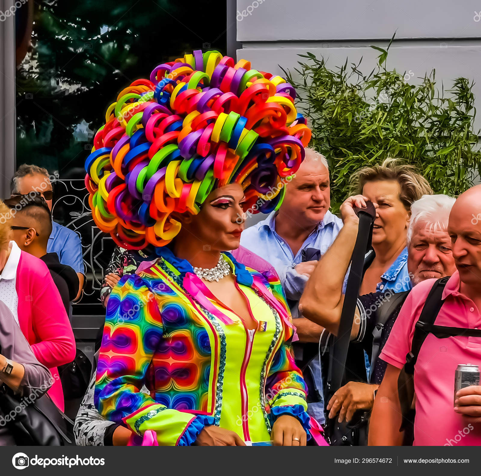 Closeup portrait of a funny drag queen wearing a rainbow wig and a