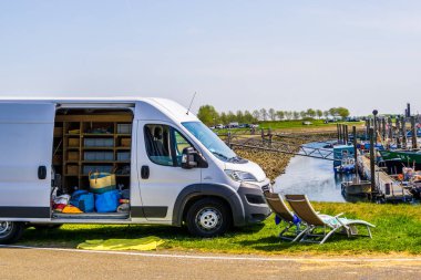 sandalyeile park edilmiş otobüs, kampçı ile tatil seyahati, popüler göçebe seyahat, Tholen, Bergse diepsluis, 22 Nisan, 2019, Hollanda