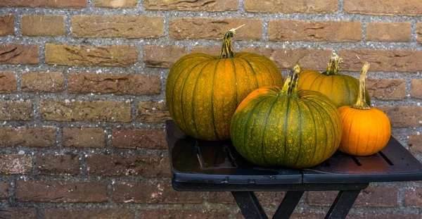 Laranja com abóboras verdes em uma mesa, decorações de Halloween e outono, fundo de tradição sazonal — Fotografia de Stock