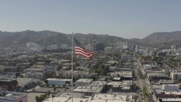 Letecký Obrácený Záběr Americké Vlajky Větru Hollywoodem Pozadí — Stock video