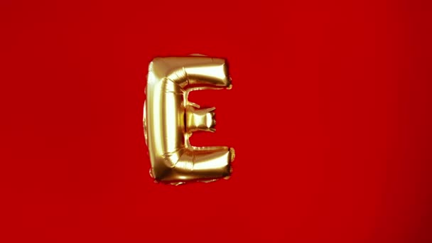 赤い背景に愛という言葉からゴールデン大きな膨脹可能な文字E バレンタインデーの創造的なおめでとうございます 結婚式への招待状 愛の宣言 — ストック動画