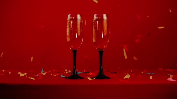 Pár Skleniček Šampaňským Pozadí Sváteční Rudé Výzdoby Padajícím Kolem Barevného — Stock video